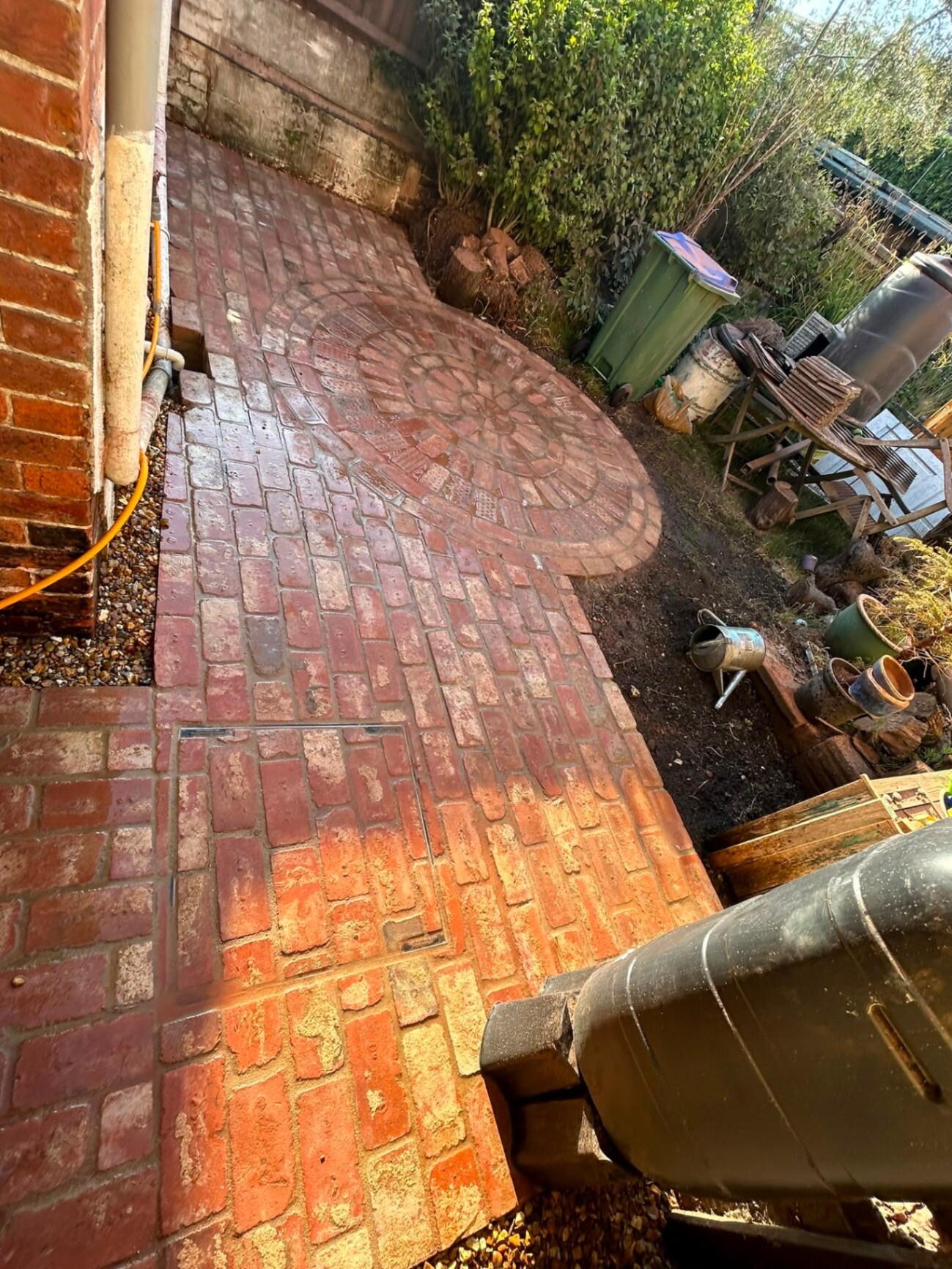 Red clay-brick driveway laid in a running-bond pattern at a Sussex home.