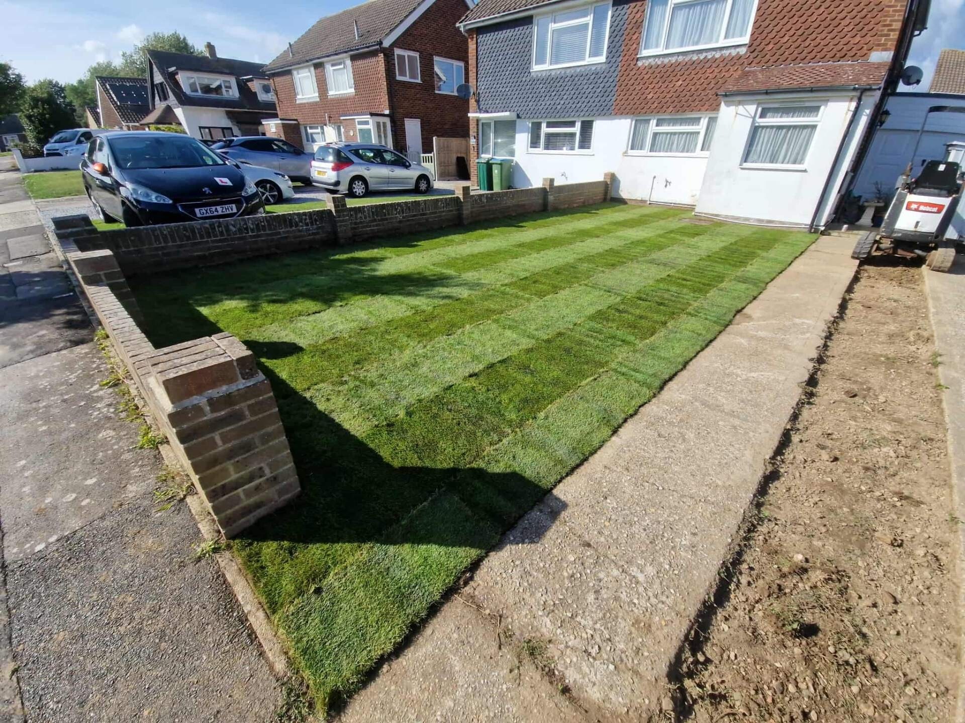 Freshly laid cultivated turf to a Sussex front lawn, alongside new block paving.