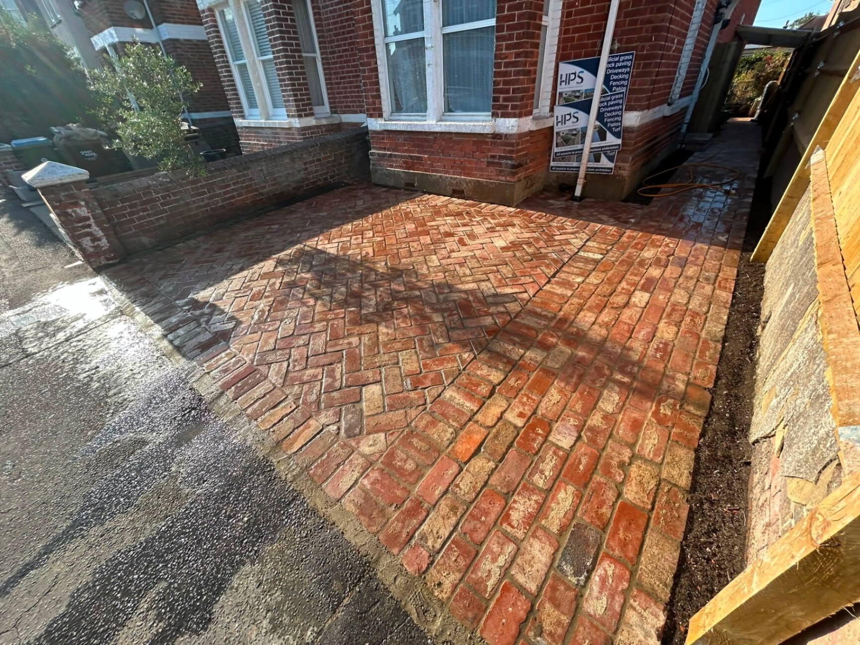 Clay-brick paving installation being laid on a freshly bedded sub-base.
