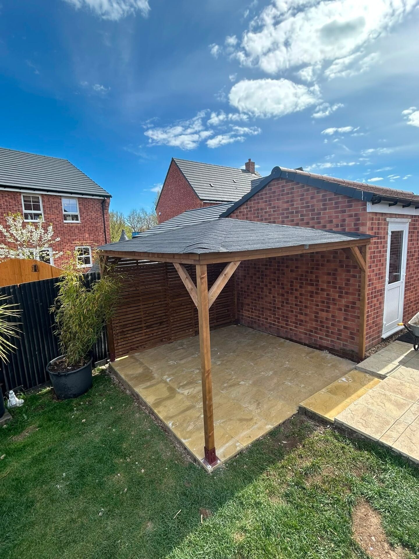 Indian sandstone patio with timber pergola and slatted fencing in a Worthing back garden.